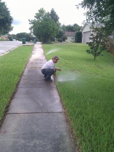 a contractor is checking the flow of a sprinkler head